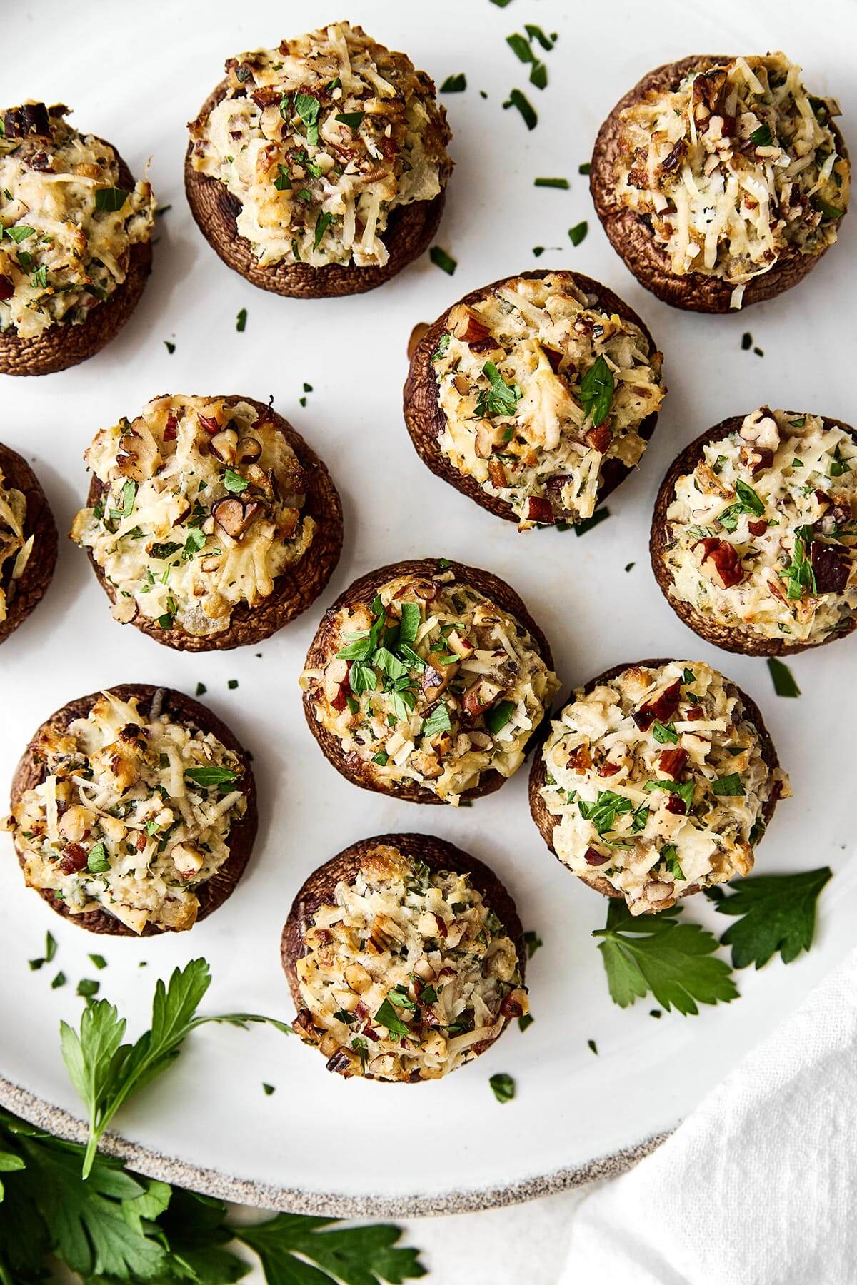 Stuffed mushrooms are always a holiday favorite! They're the perfect cheesy mushroom bite with hints of onion, herbs, and pecans. A plate of stuffed mushrooms.