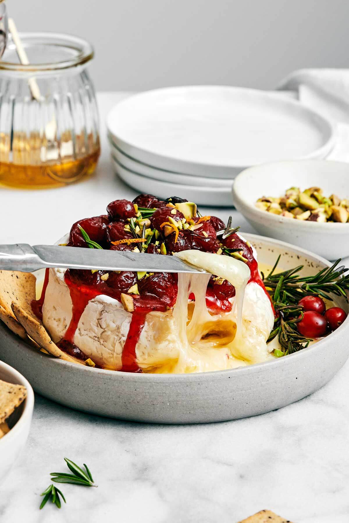 The most perfect baked brie with cranberry sauce for a festive, holiday appetizer! Plus, it's made in under 10 minutes. Melty baked brie with cranberry sauce.