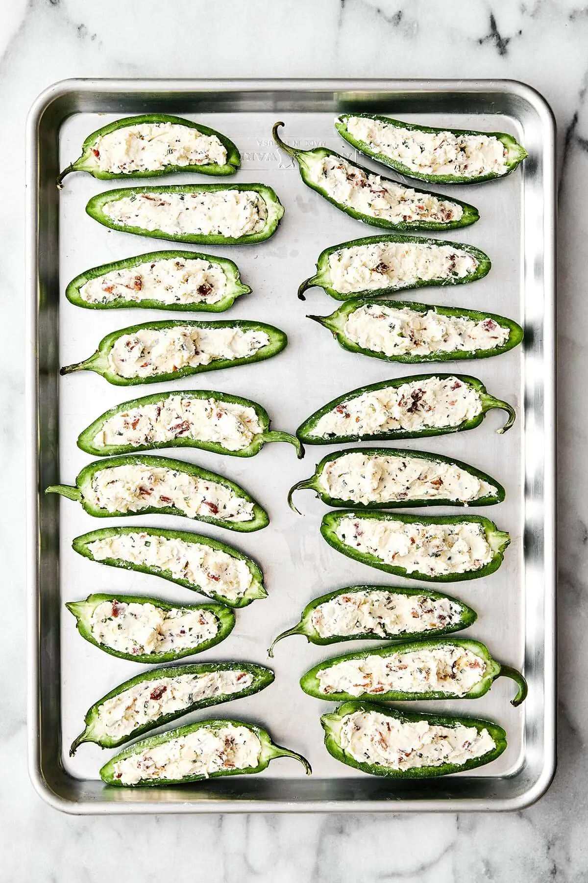 These jalapeño poppers are the ultimate party appetizer—especially for game day! They're cheesy, savory, and dotted with crispy bacon. Prepping jalapeño poppers.