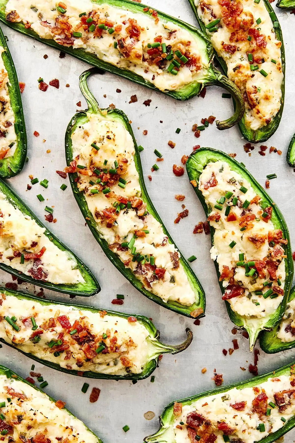 These jalapeño poppers are the ultimate party appetizer—especially for game day! They're cheesy, savory, and dotted with crispy bacon. A sheet pan of jalapeño poppers.