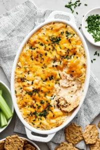A baking dish with crab dip and crackers.