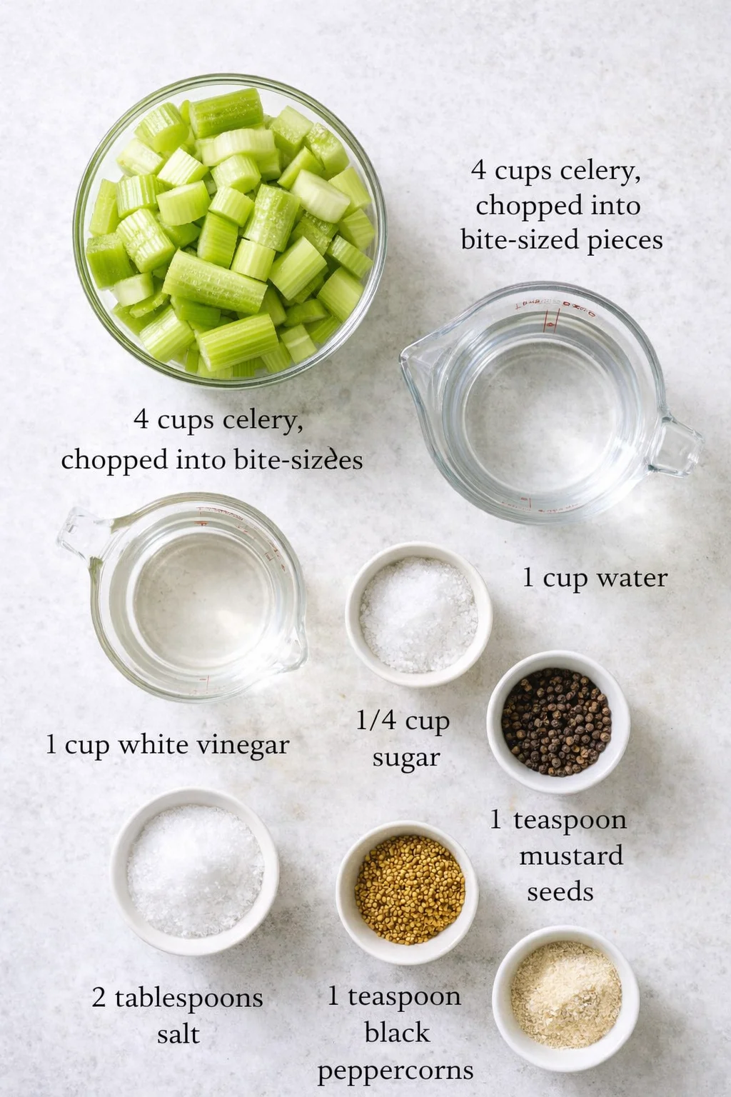Overhead shot of chopped celery in a glass bowl with measuring cups and labeled ingredients on a light countertop.
