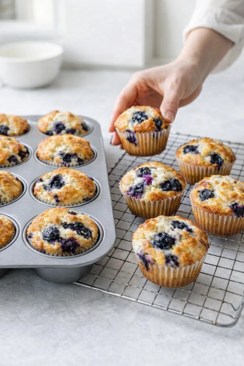 step-process-placeholder-9-10.png Golden muffins baking in pan, then cooling briefly before being transferred to a wire rack.