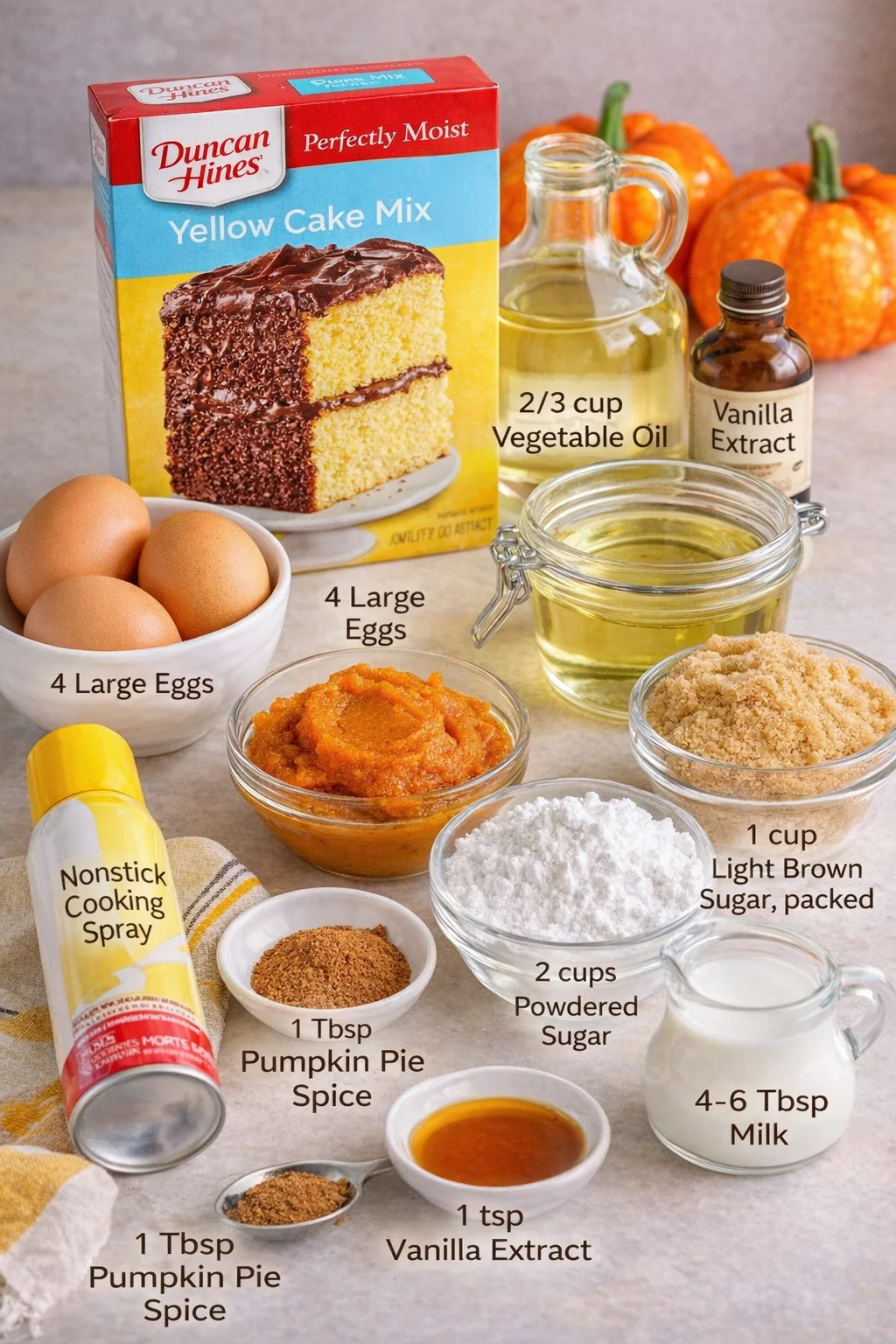 Measured ingredients arranged for Pumpkin Honey Bun Cake: 1 box Duncan Hines yellow cake mix (Ignore the instructions on the box for this recipe), 2/3 cup vegetable oil, 4 large eggs, 1 cup pure pumpkin puree (not pumpki