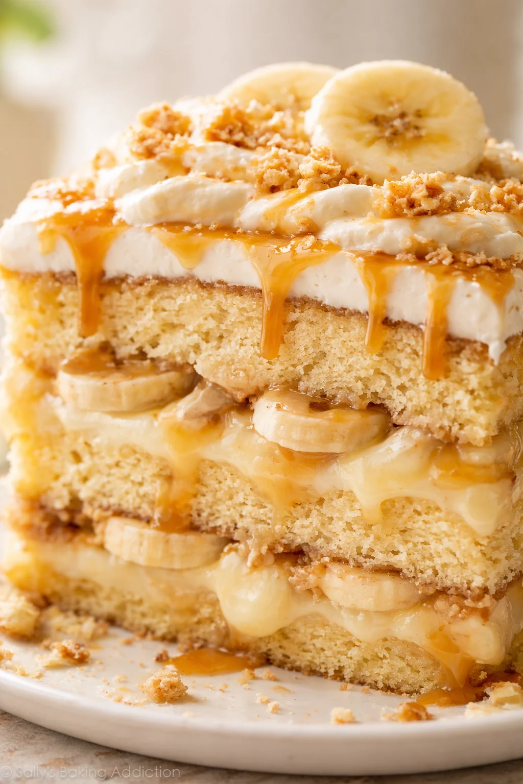 Close-up of a tall banana cake with caramel drizzle and banana slices.