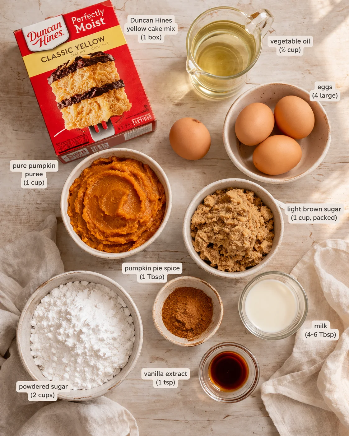 Overhead view of pumpkin bars ingredients arranged on a light wooden surface.
