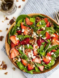 The best ever spinach strawberry salad with balsamic poppy seed dressing, pecans, and feta or goat cheese.