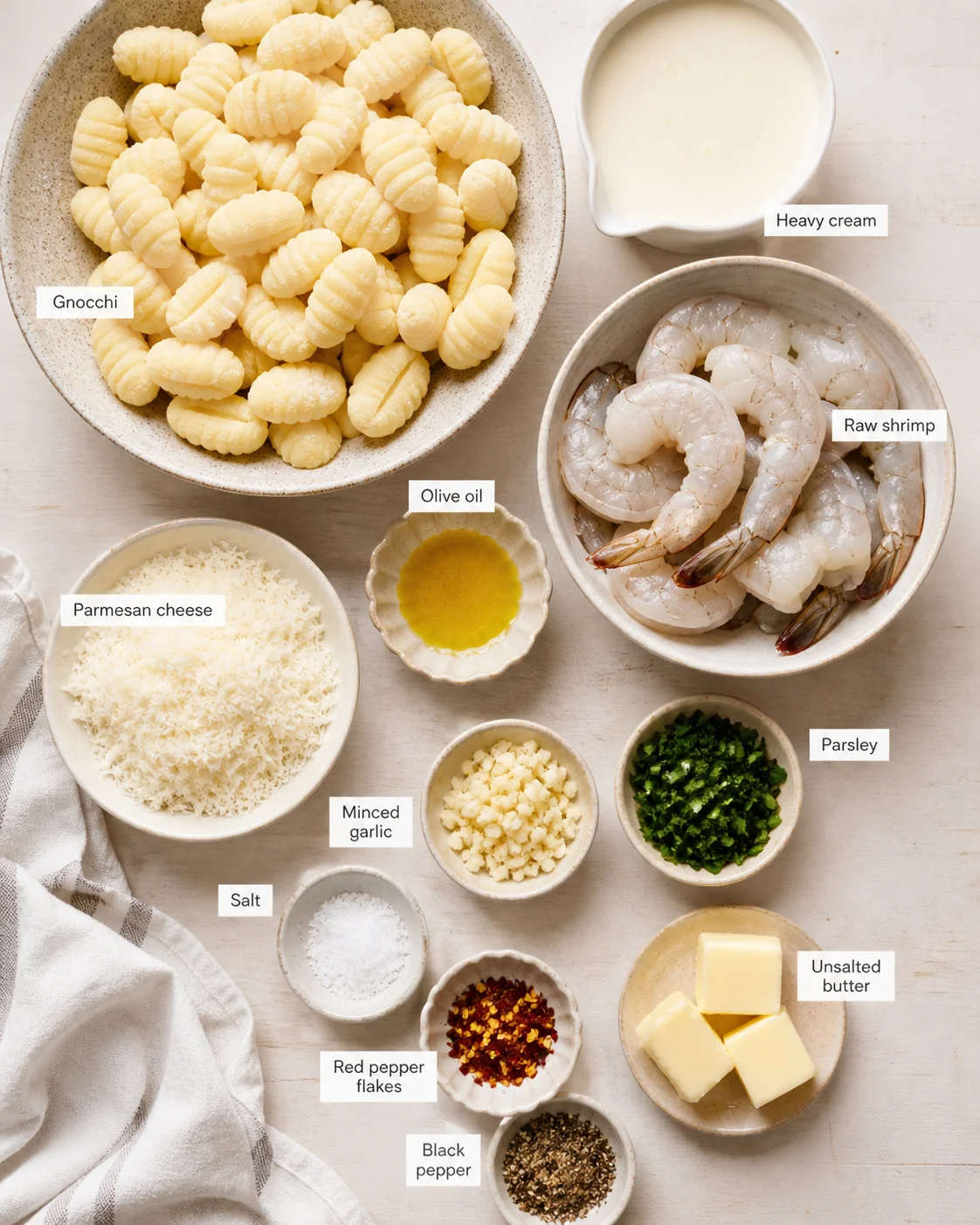 Flat lay of gnocchi, raw shrimp, heavy cream, cheese, herbs, and spices with labeled tags.