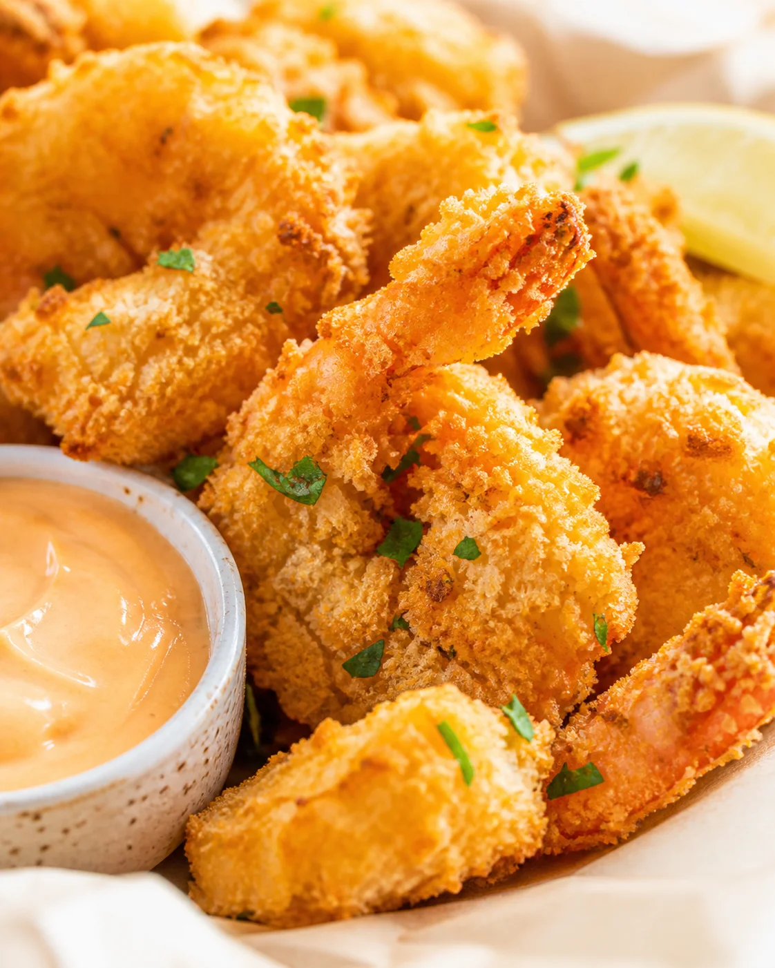 Golden fried bites with creamy dipping sauce and a lemon wedge