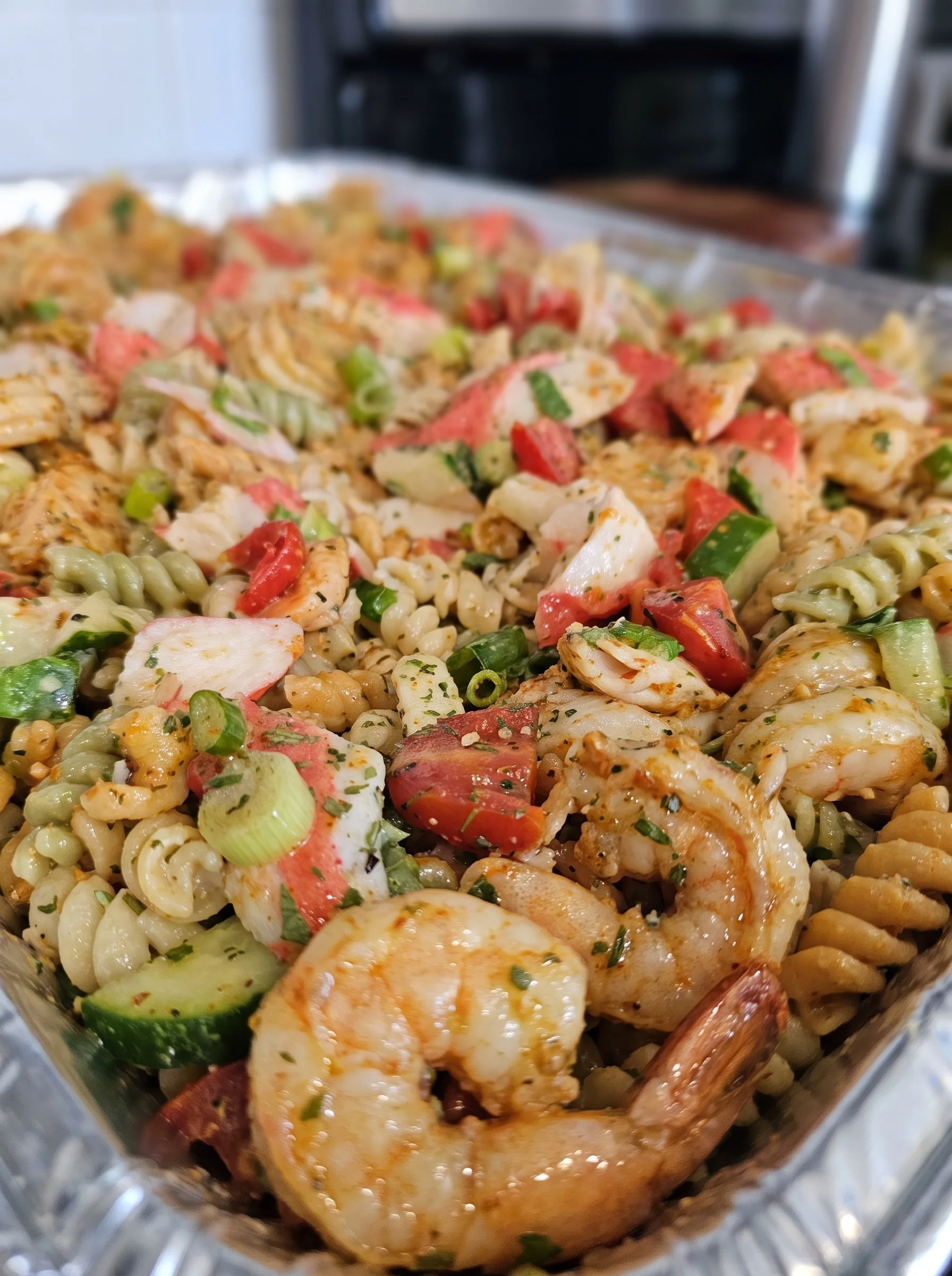 Colorful seafood pasta salad with shrimp, crab, vegetables, and Italian dressing.