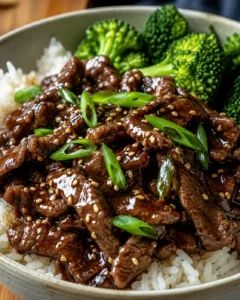 Delicious slow cooker Mongolian beef served with rice and broccoli.